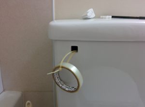 Fix the broken toilet handle using zip ties and tape