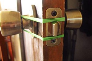 Add a Rubber Band to Door Knobs to Soften Slamming Doors